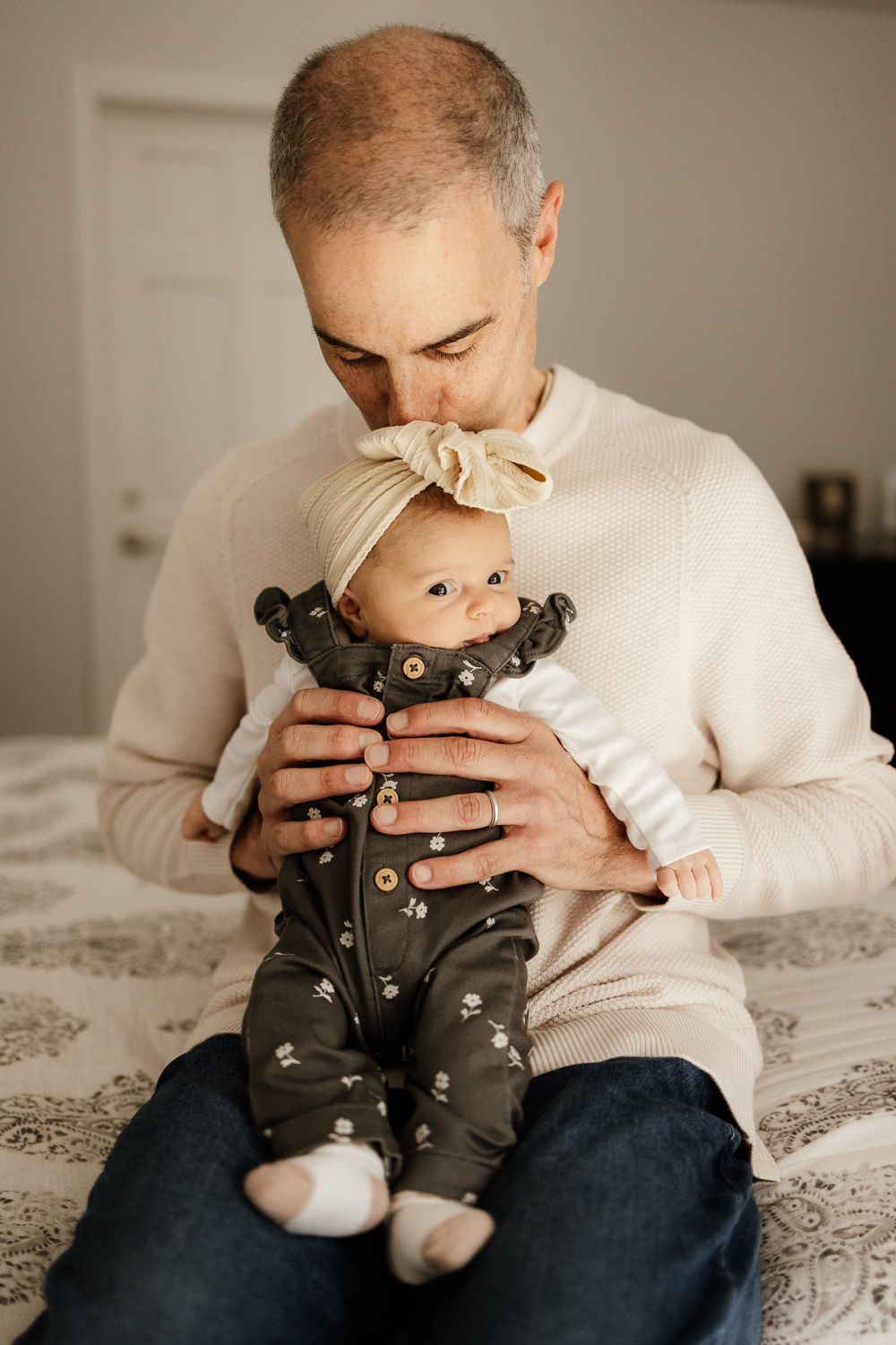 Grandpa holds kisses baby at lifestyle in-home photoshoot with Newborn Photographer Cindy Tucey in Los Gatos