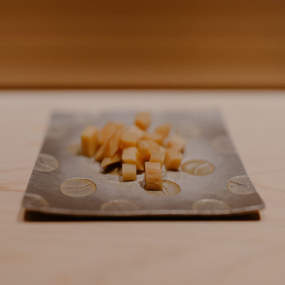 Small cubed ingredients arranged on a textured gray ceramic plate.