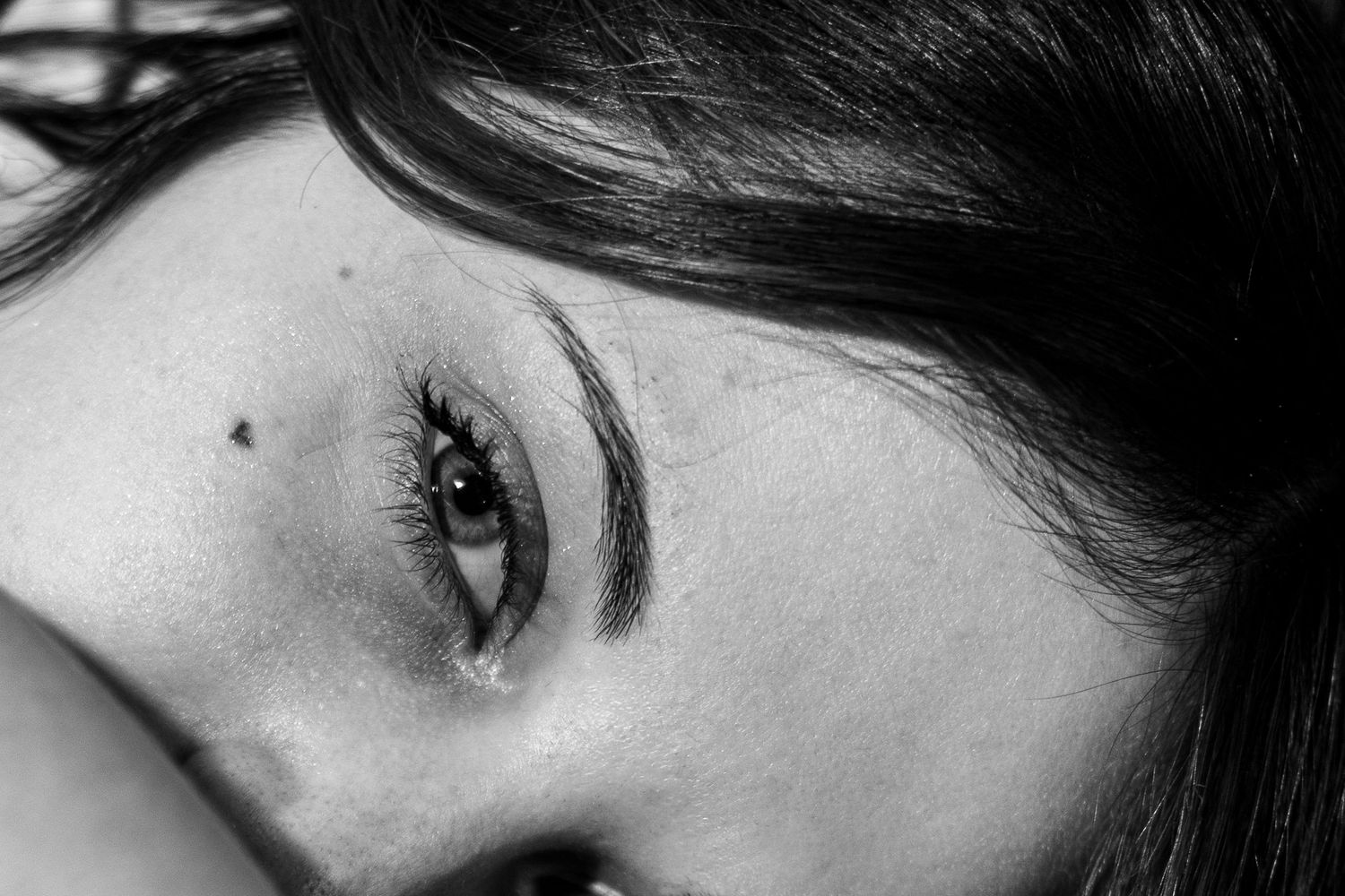 A series of black and white portrait photographs showing close-up views of eyes and facial features.