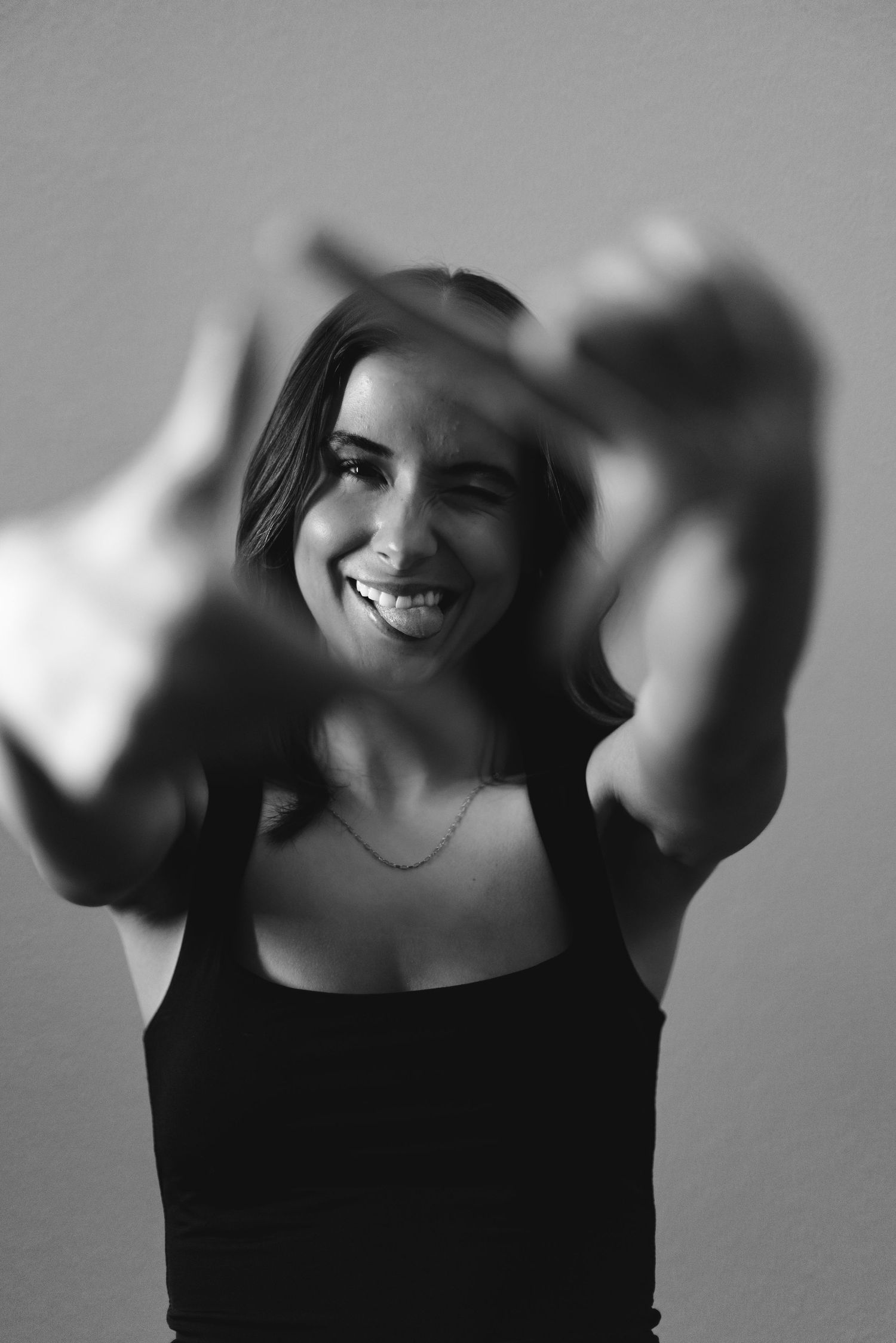 Black and white portrait with dynamic hand movement and joyful expression.