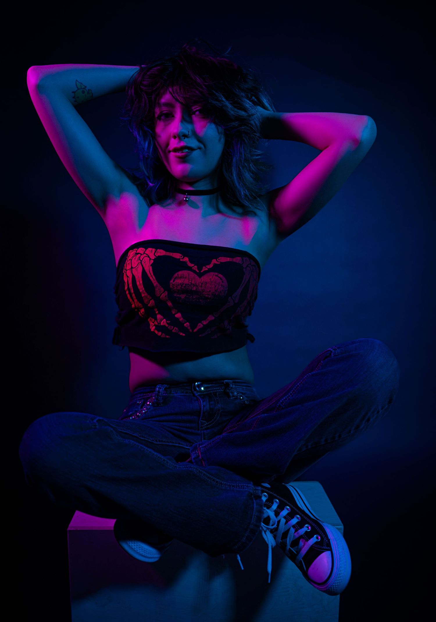 Artistic portrait series in dark lighting with neon blue and pink colors showing cropped body poses against black background.