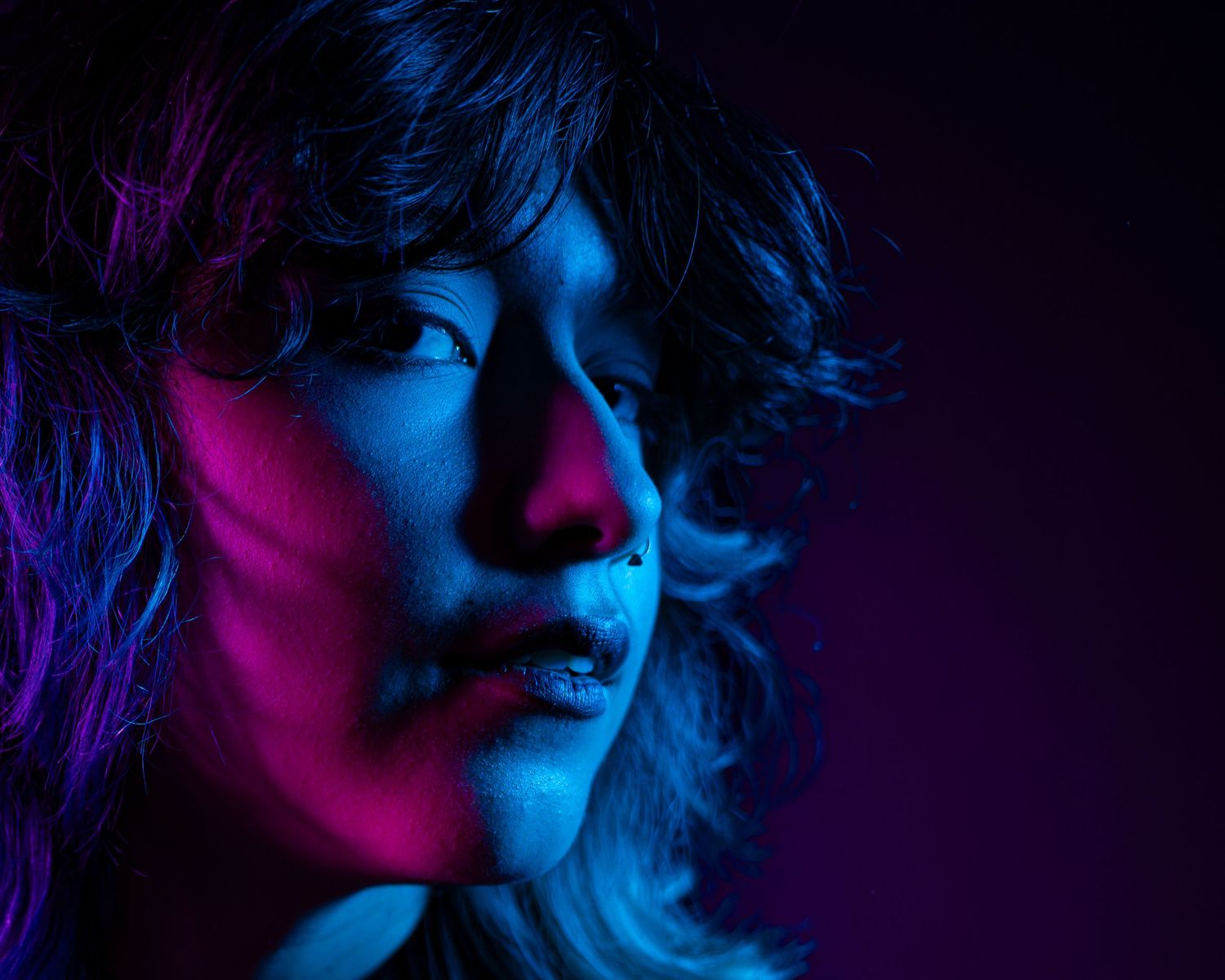 A dark moody portrait series with dramatic neon blue and red lighting creating a cyberpunk aesthetic in low-key style.