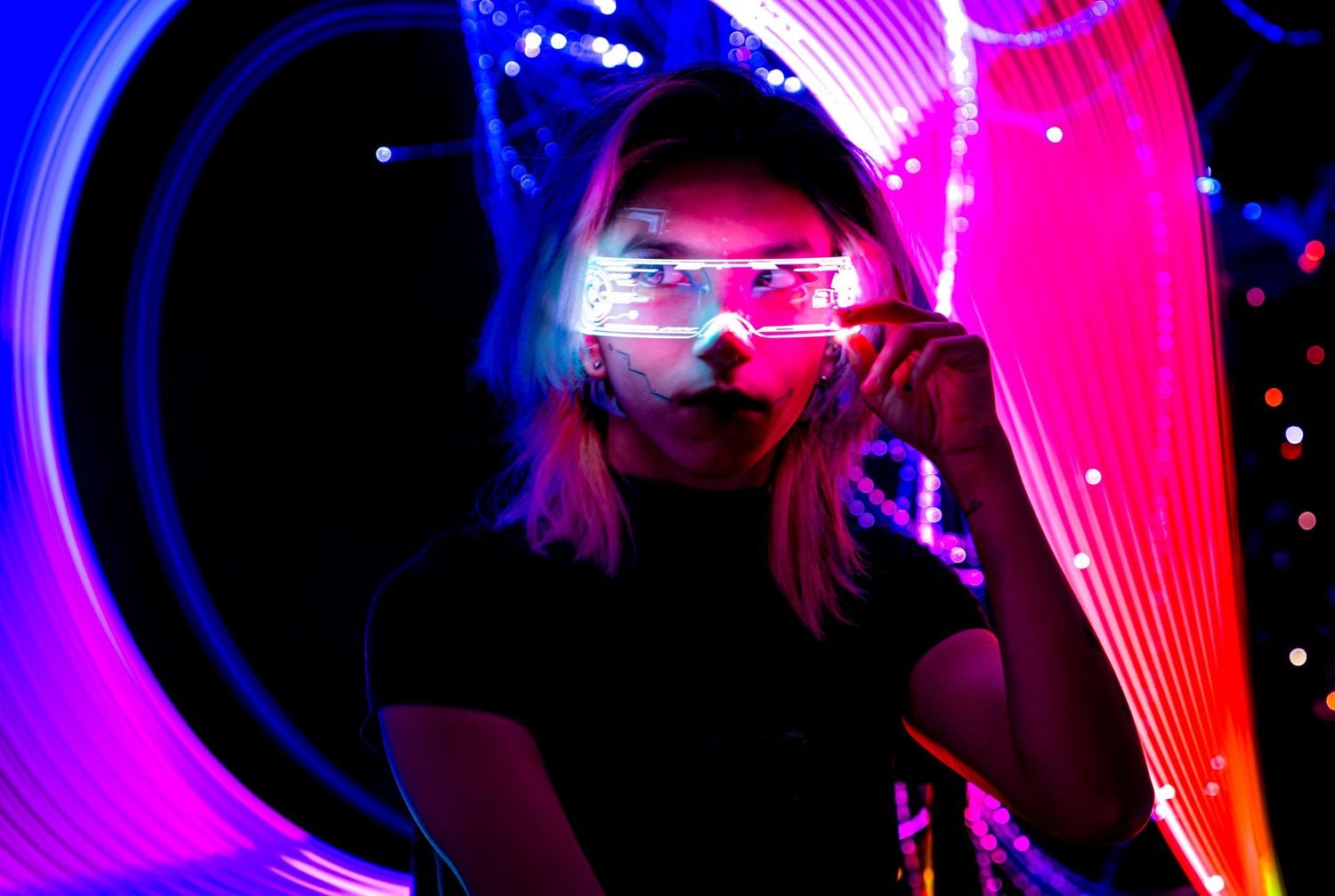 Neon pink and blue lights create a vibrant nightclub atmosphere with silhouettes moving in the darkness.