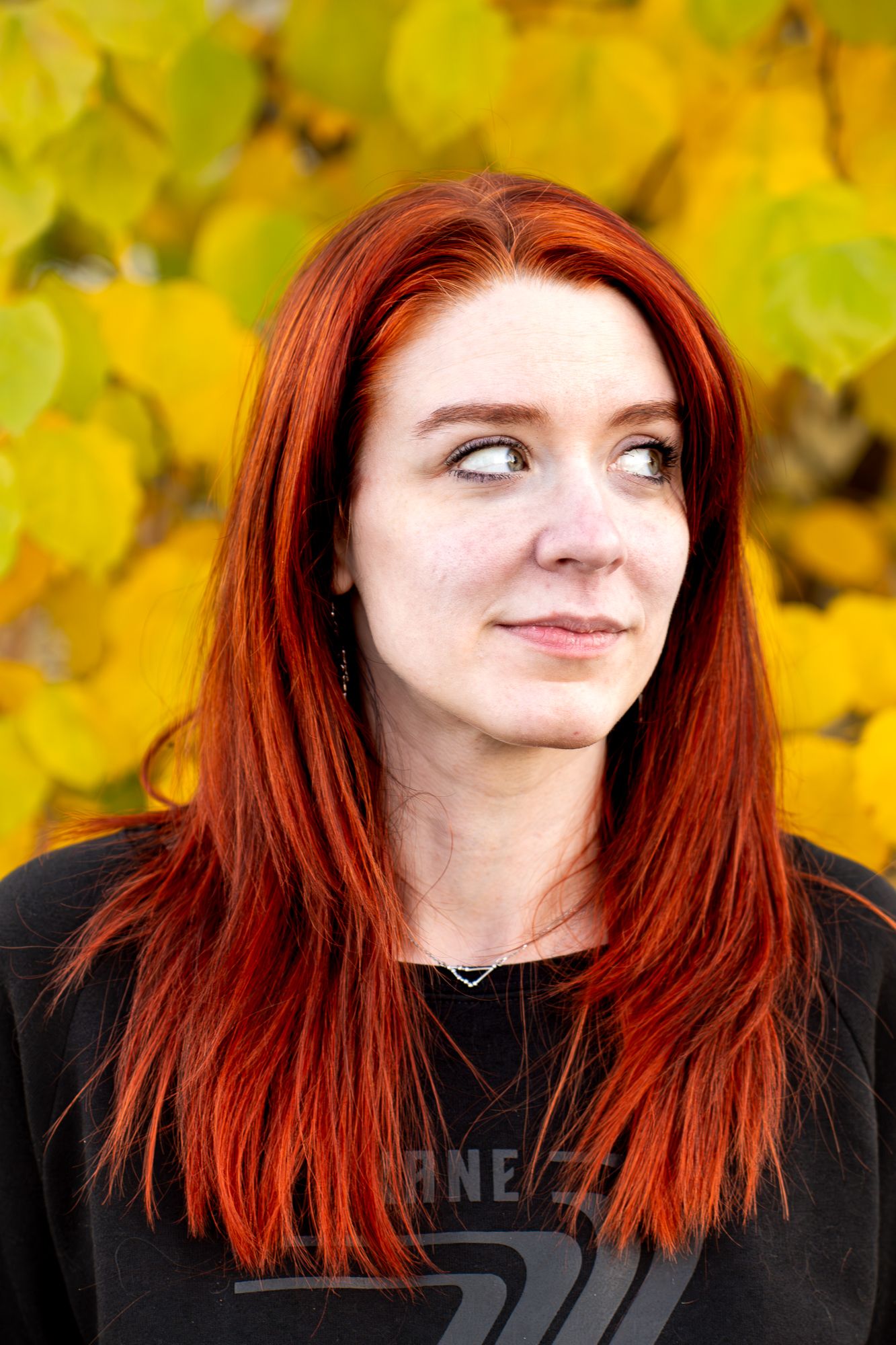 A series of five sequential photos showing someone with vibrant red hair making playful expressions against autumn foliage.