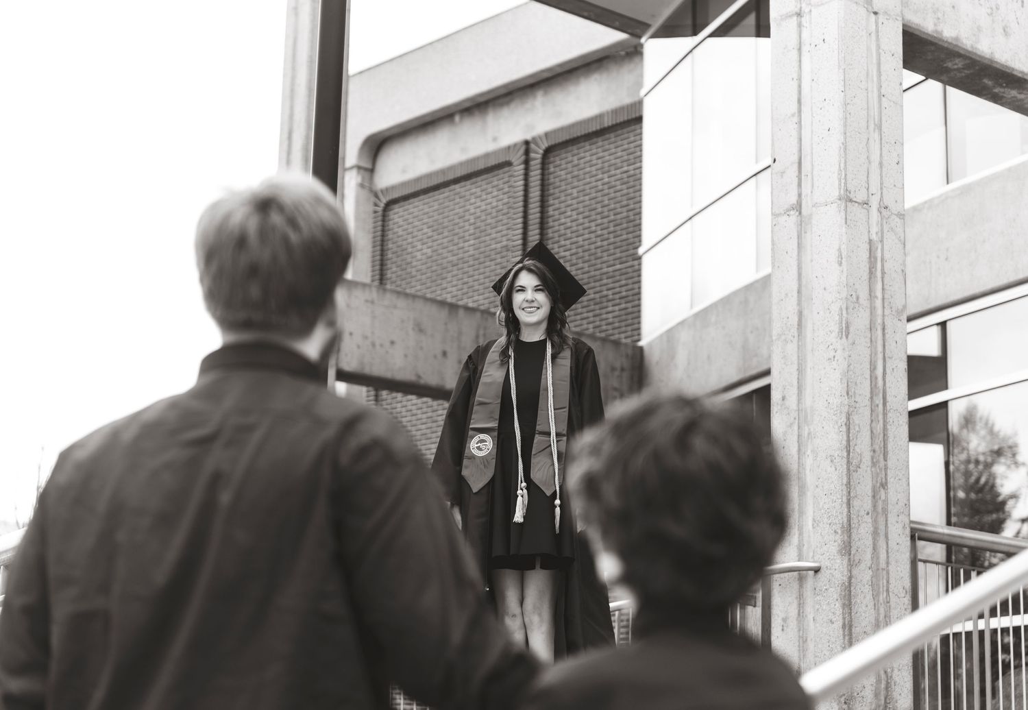 A black and white photograph shows a group of people gathered around a building entrance.