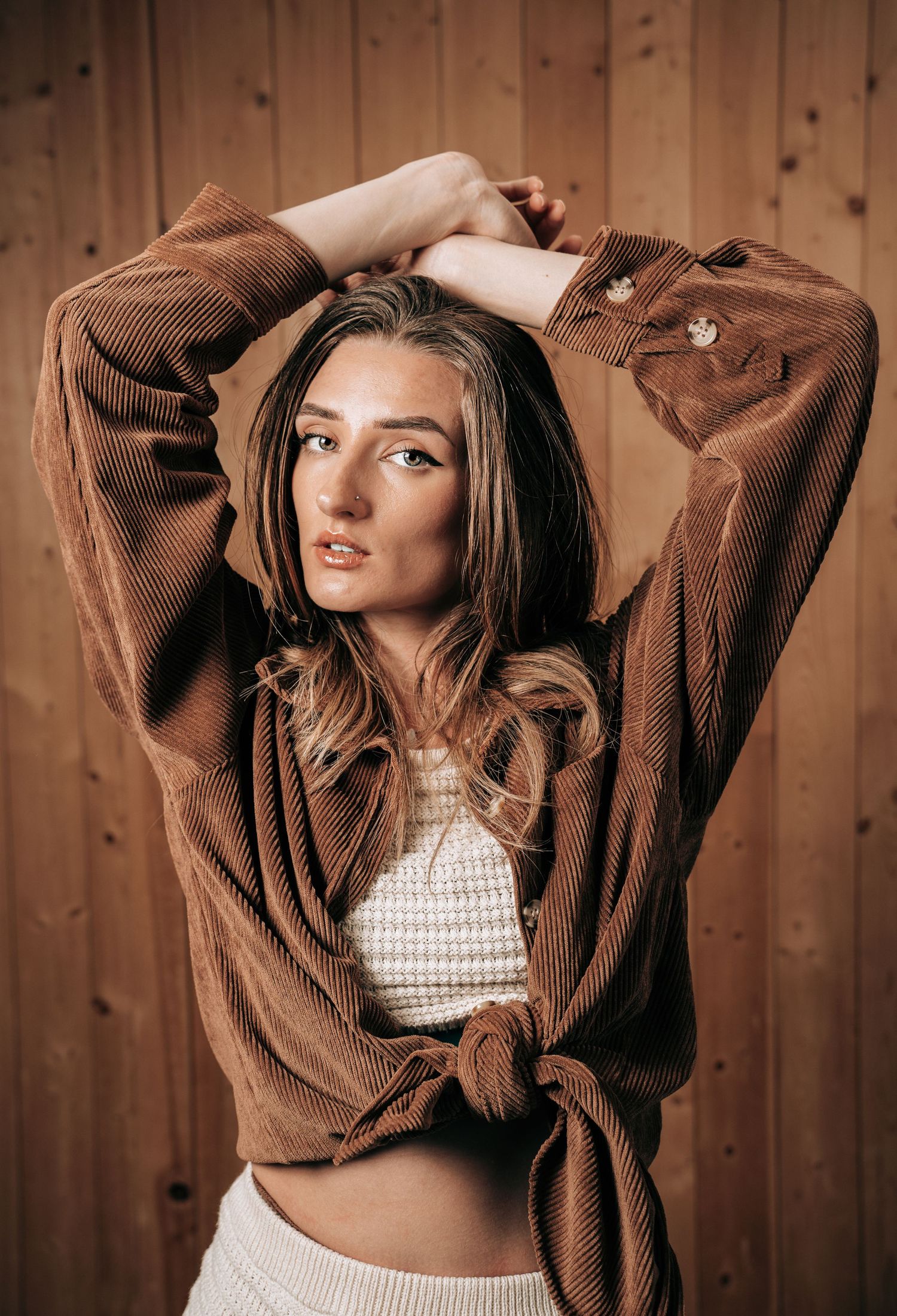 A series of four photos showing a person in a brown sweater and white top posing against a wooden wall background.