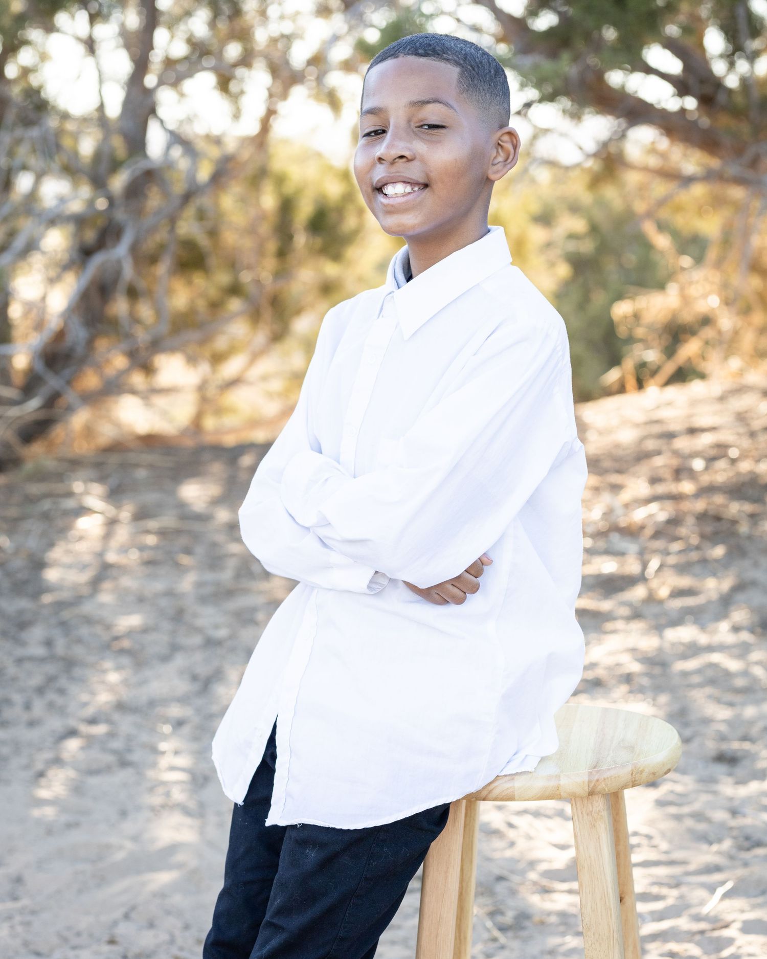 A portrait of a child posing while sitting on a chair during golden hour.