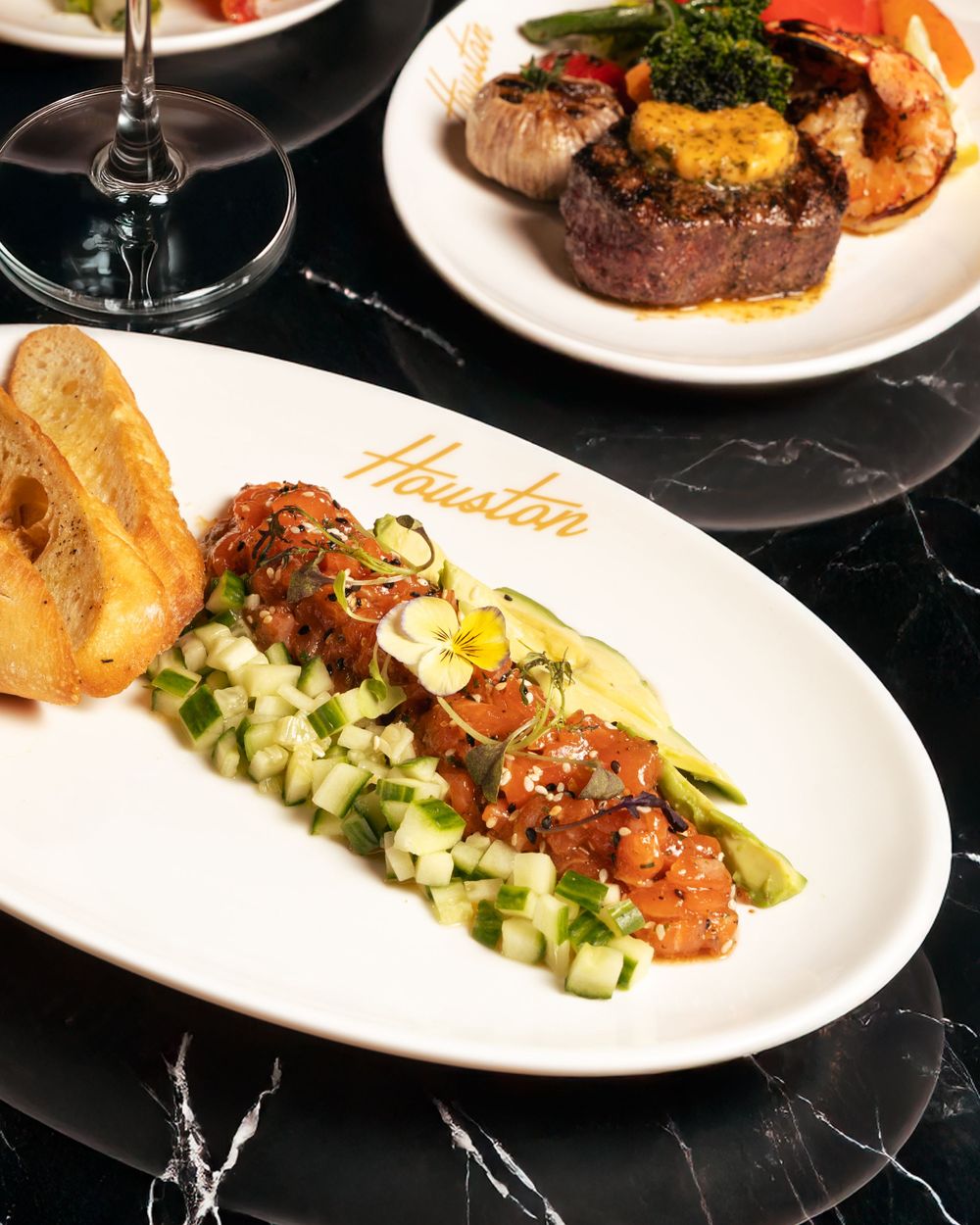 Grilled steak with scallops and seafood appetizer on white plates with elegant garnishes. Mtlshutter photography