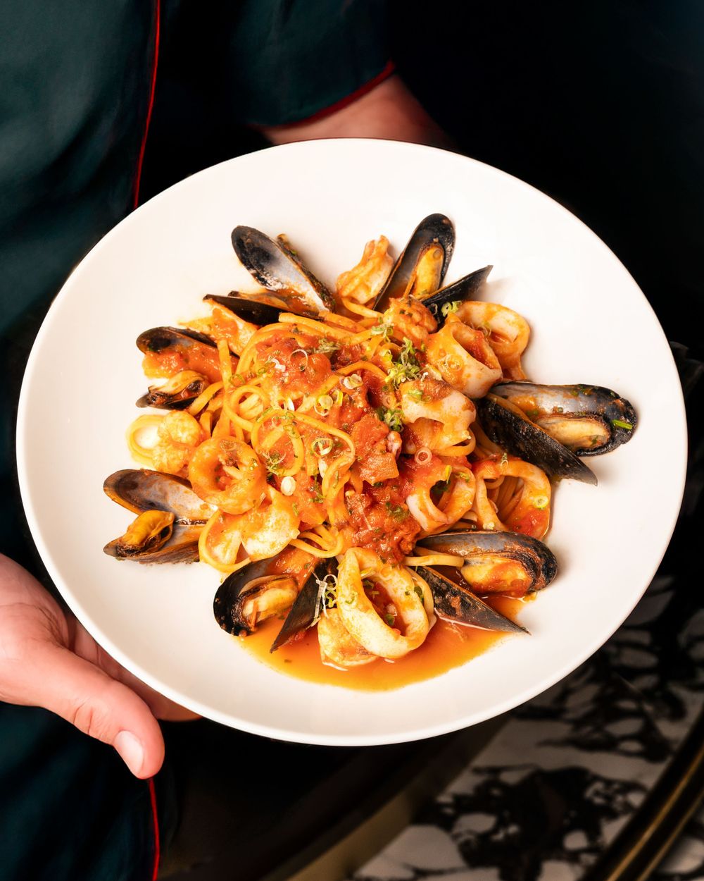 Seafood pasta dish with mussels and shrimp in tomato sauce on white plate. Mtlshutter photography