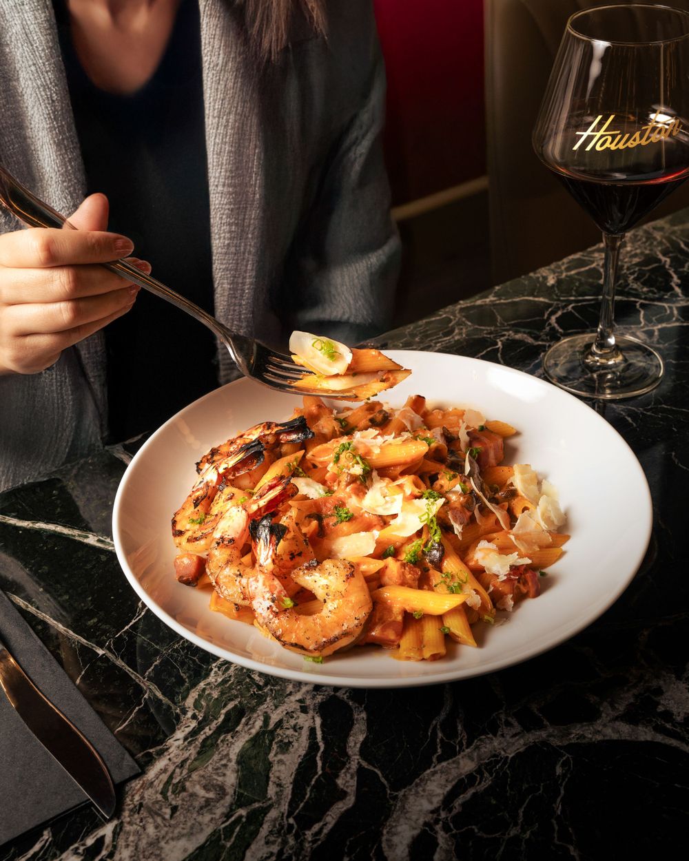 Stir-fried shrimp dish with vegetables served alongside red wine in an upscale restaurant setting. Mtlshutter photography