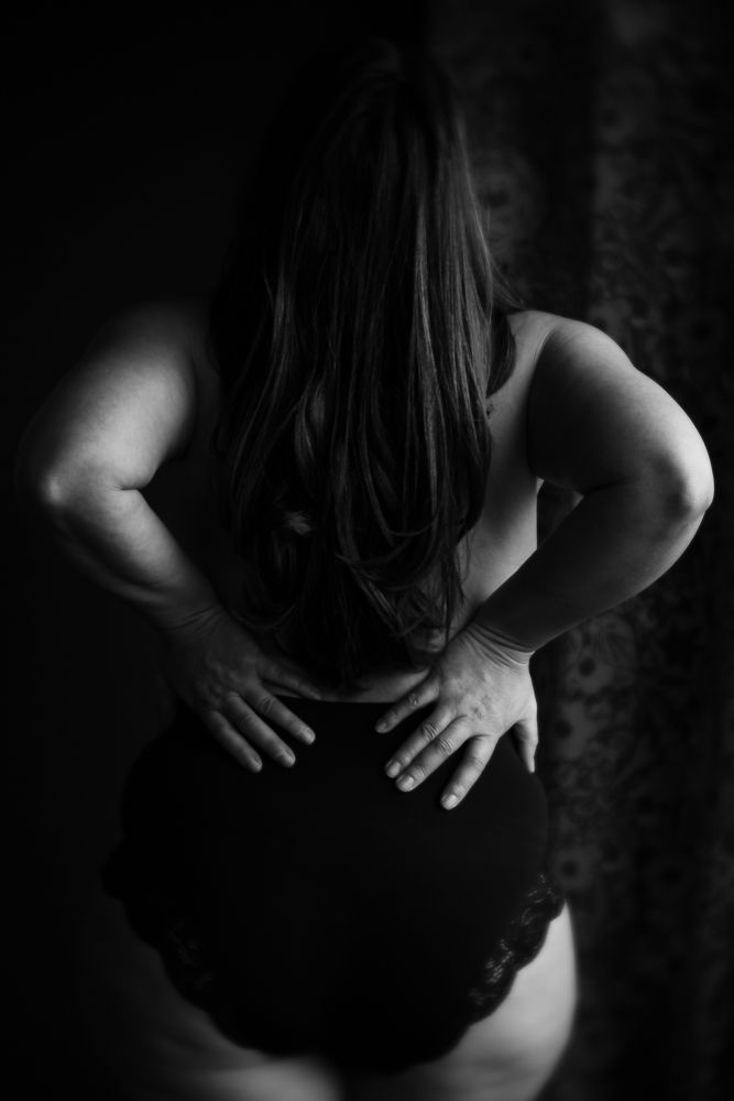 Dramatic black and white photo of figure in dark bodysuit.