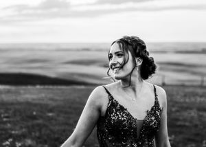 Black and white portrait of a smiling woman in a sequin dress outdoors. Senior grad photos. Graduation photos.