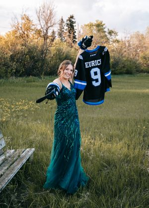 Woman in green sequin gown holding up a hockey jersey number 9 Eurico outdoors. Senior grad photos. Graduation photos.