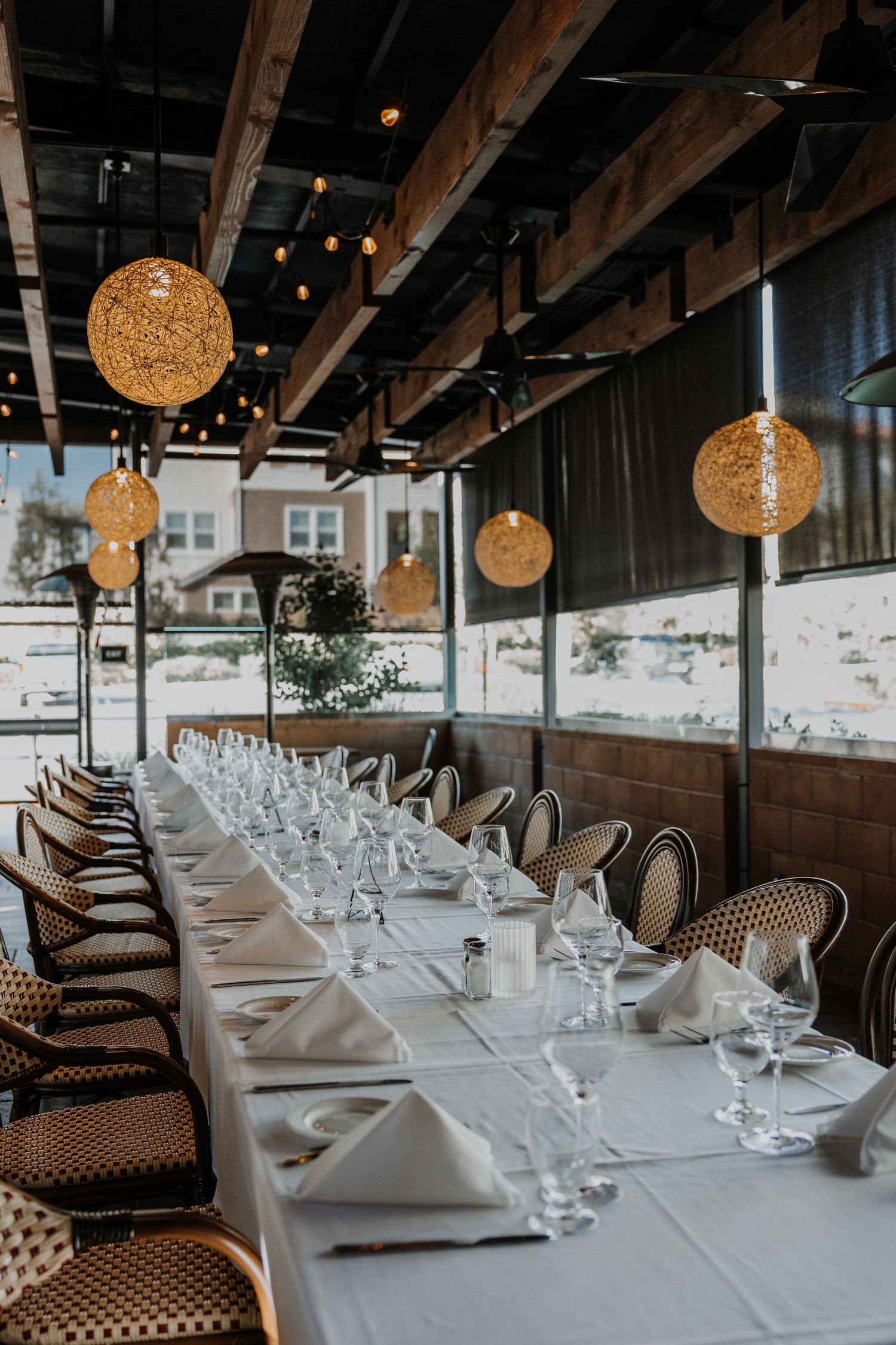 Elegant restaurant dining room with white tablecloths and golden sphere pendant lights.