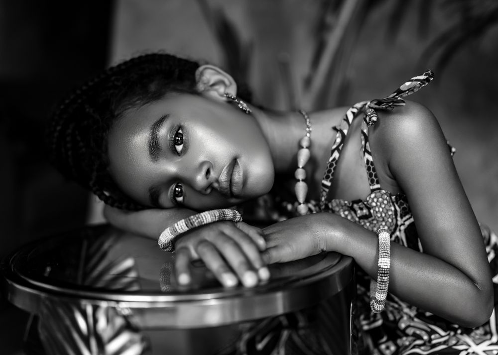 A dramatic black and white portrait showing artistic lighting and elegant jewelry.