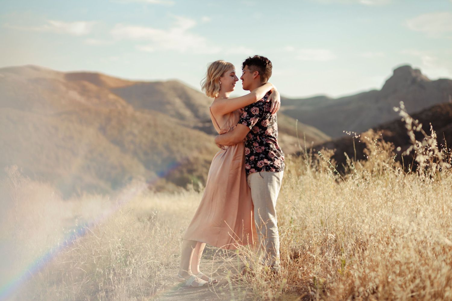 Couple standing, hugging in a golden field.
