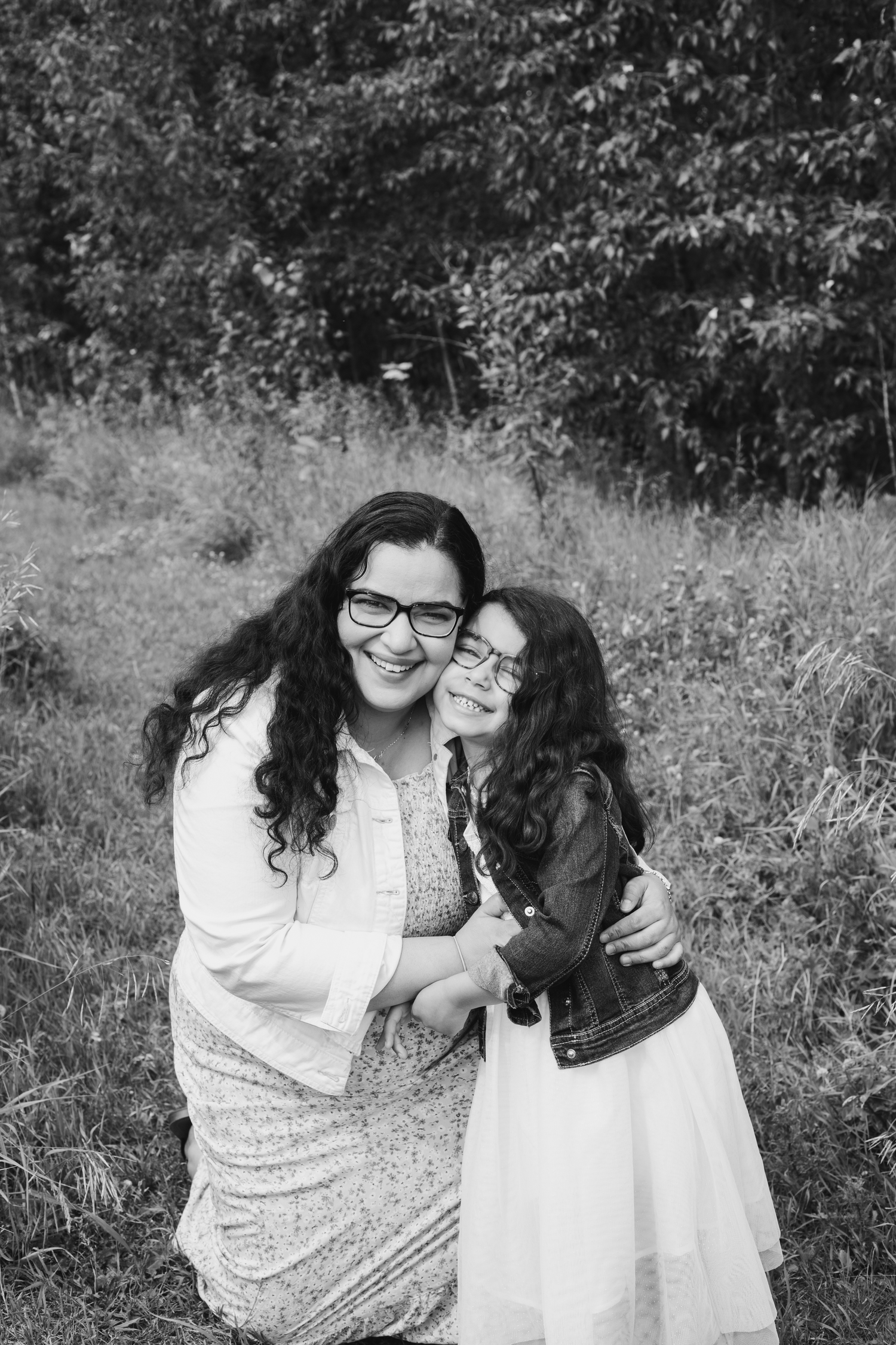 Mother and daughter cozied up with big smiles at the camera.