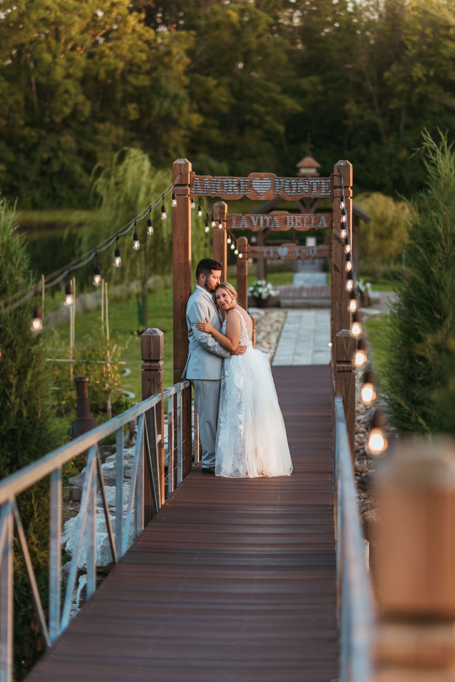 A romantic evening scene on an illuminated wooden bridge decorated with string lights.