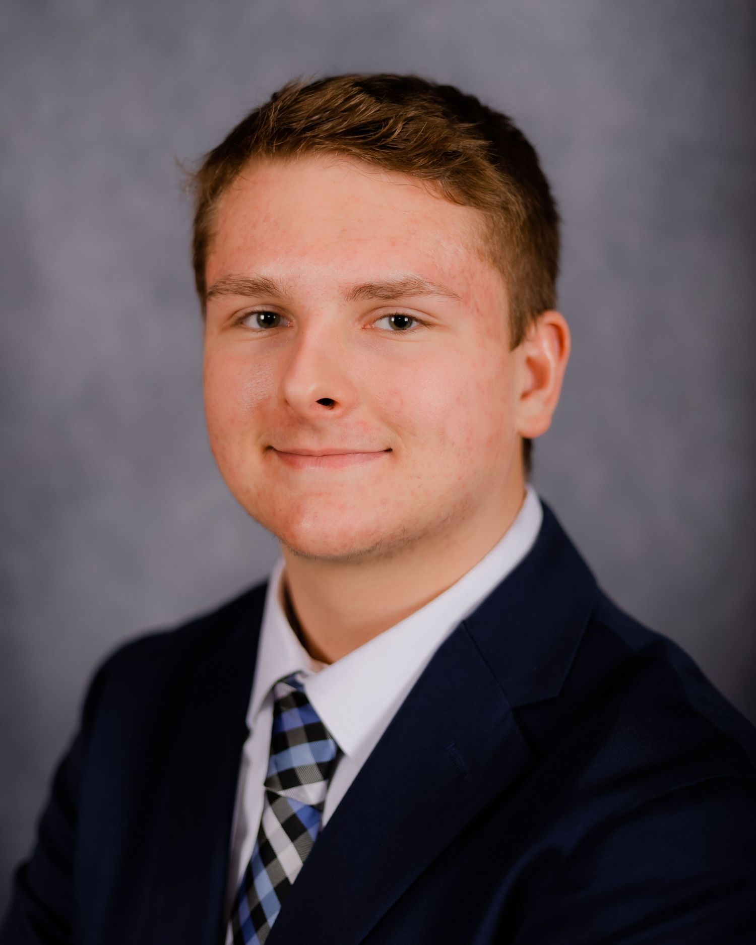Professional portrait photo series showing a student in a navy suit and striped tie against a gray backdrop.