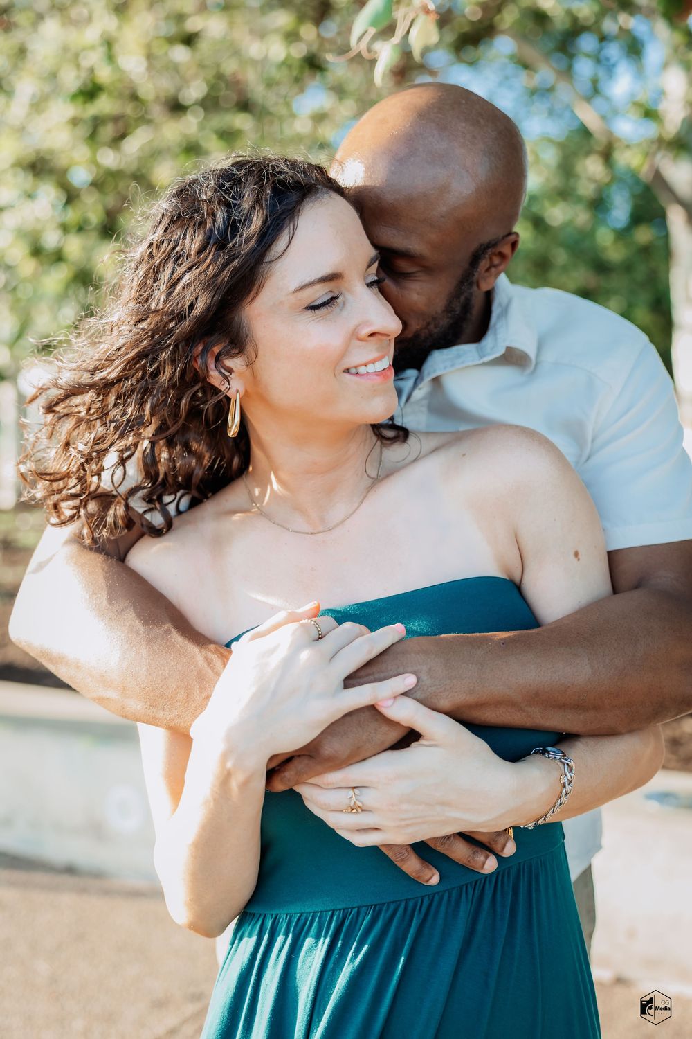 A romantic couple embraces outdoors in a series of intimate poses, with one person wearing a teal dress.