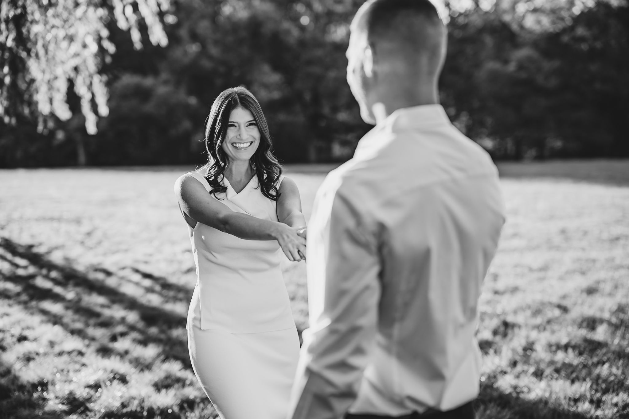 Candid moments captured in black and white beneath garden trees.