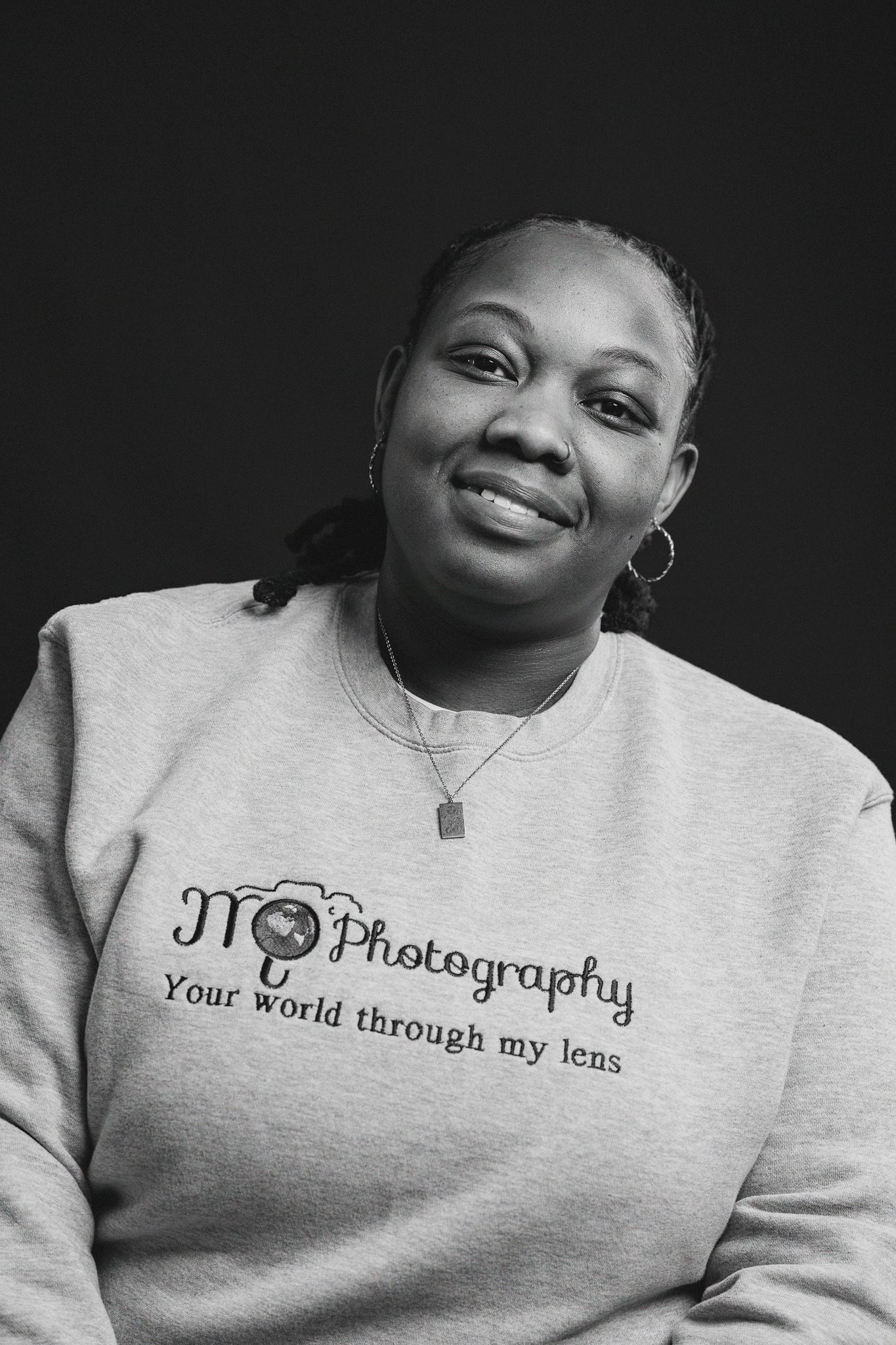 Person wearing photography-themed sweatshirt in black and white portrait series.