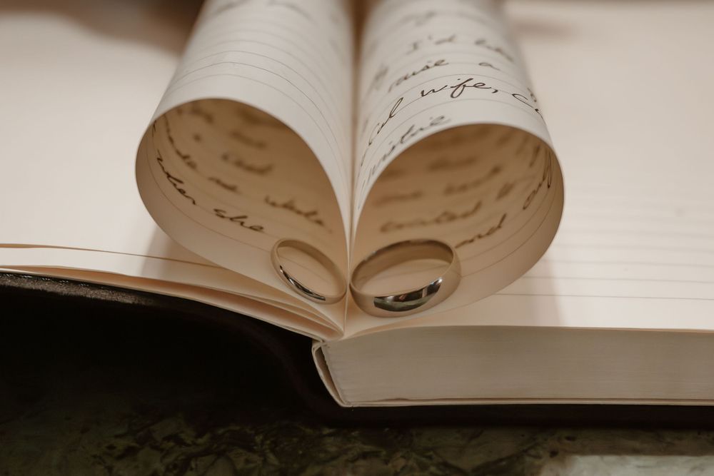 Whitley Hall - An open book with handwritten text on curled pages photographed in warm sepia tones.