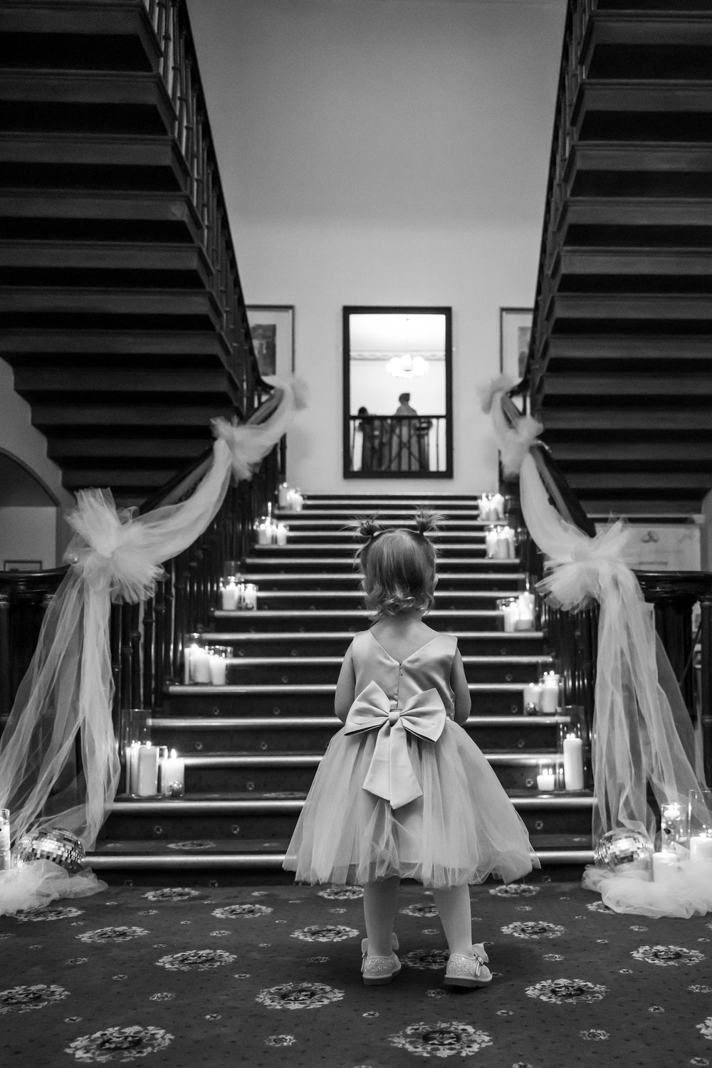 Wortley Hall - A sequence of black and white photos showing a small child in a dress and bow standing on a patterned carpet near stairs.