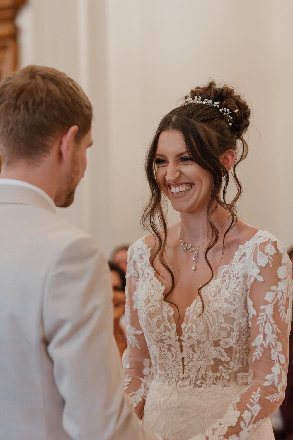 Wortley Hall - A couple shares a joyful moment during their wedding, with the bride wearing an elegant lace-detailed dress.