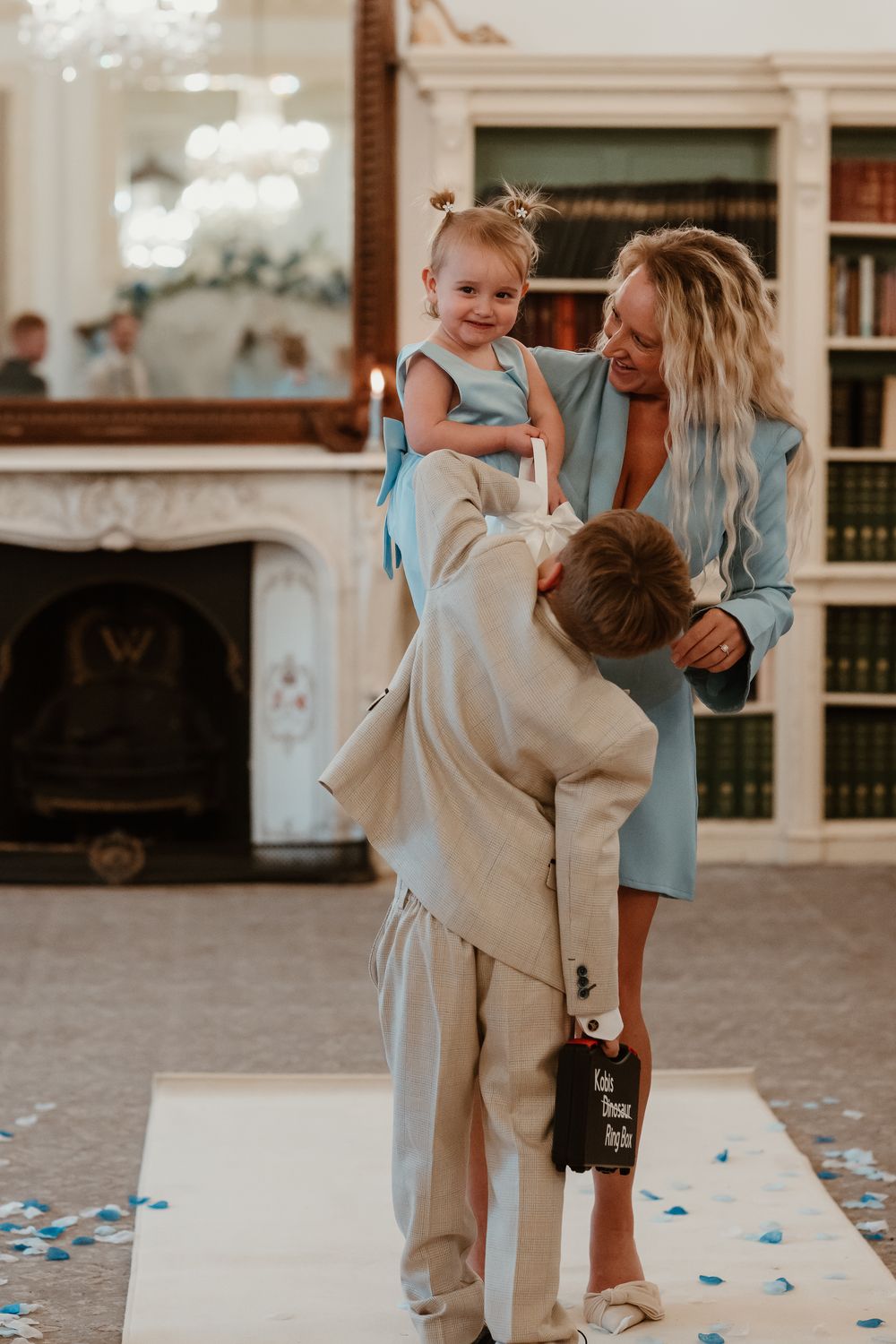 Wortley Hall - A young child in a beige suit dances and twirls with someone in a blue dress at a celebration.