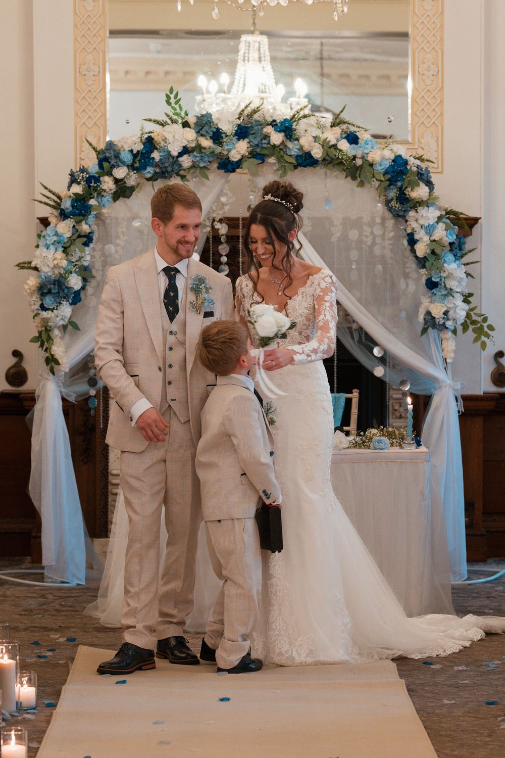Wortley Hall - Wedding couple shares romantic moments during indoor ceremony decorated with blue and white floral arrangements.
