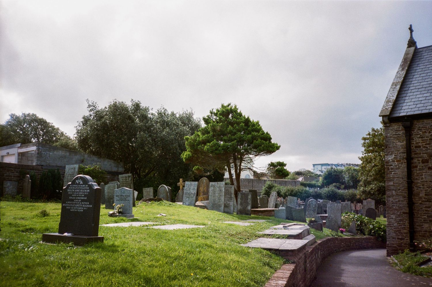 Panoramic view of a grassy hillside cemetery overlooking the coastline.