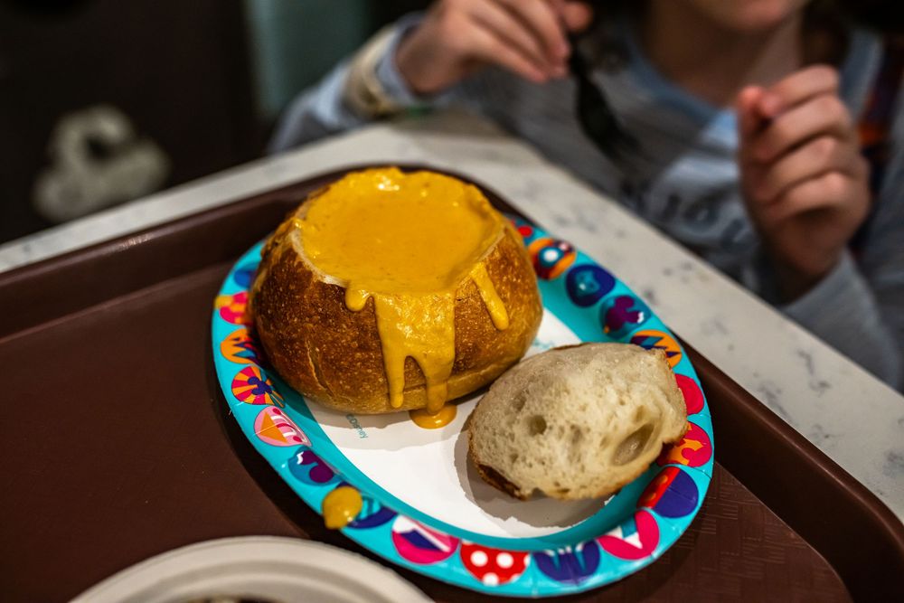 Close-up of golden-colored dome-shaped desserts served on colorful patterned plates.