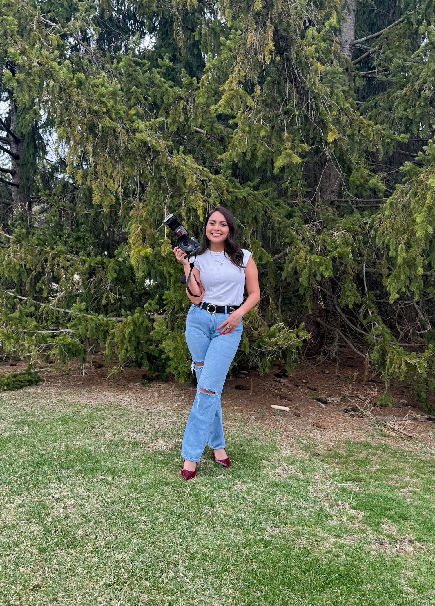 Candid moments captured on a grassy slope with evergreen trees in the background.