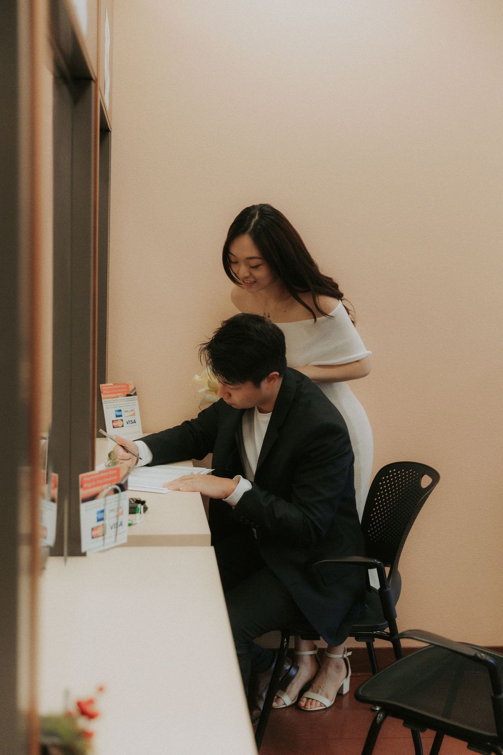 Business professionals working at a desk in an office setting with documents and paperwork.