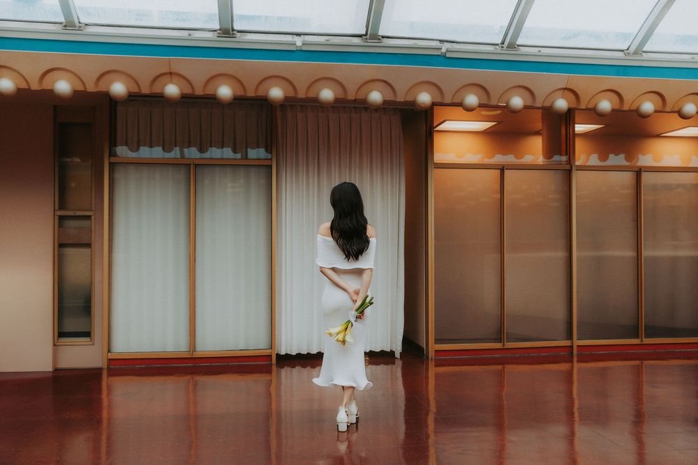 A modern dance studio with hardwood floors, mirrored walls, and ballet barres mounted along the perimeter.