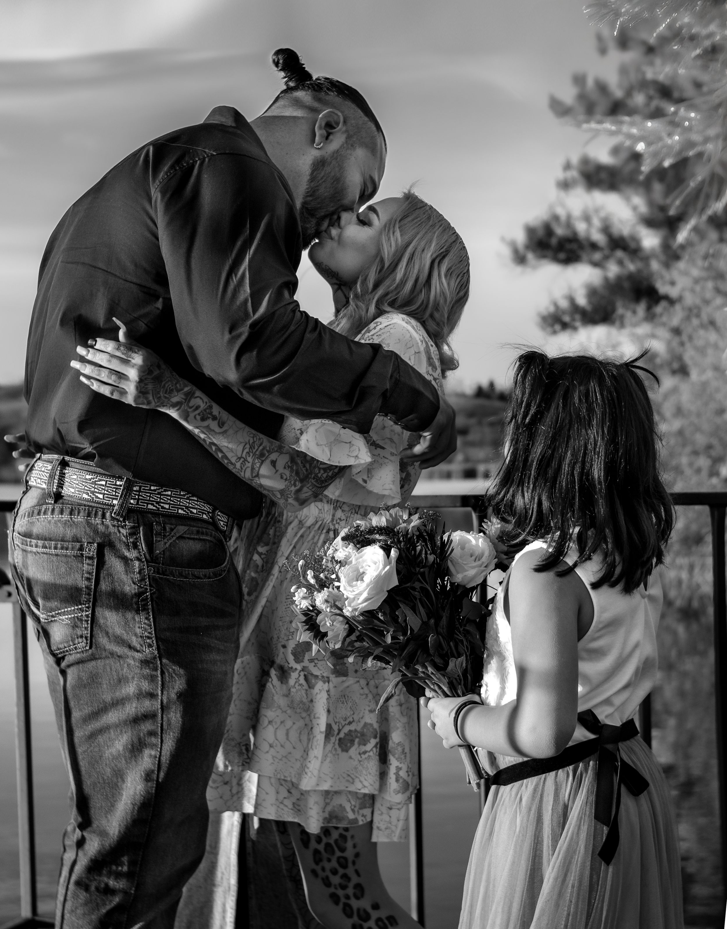 A sequence of black and white photographs showing two people sharing a tender moment against a natural outdoor backdrop in Williston, ND.
