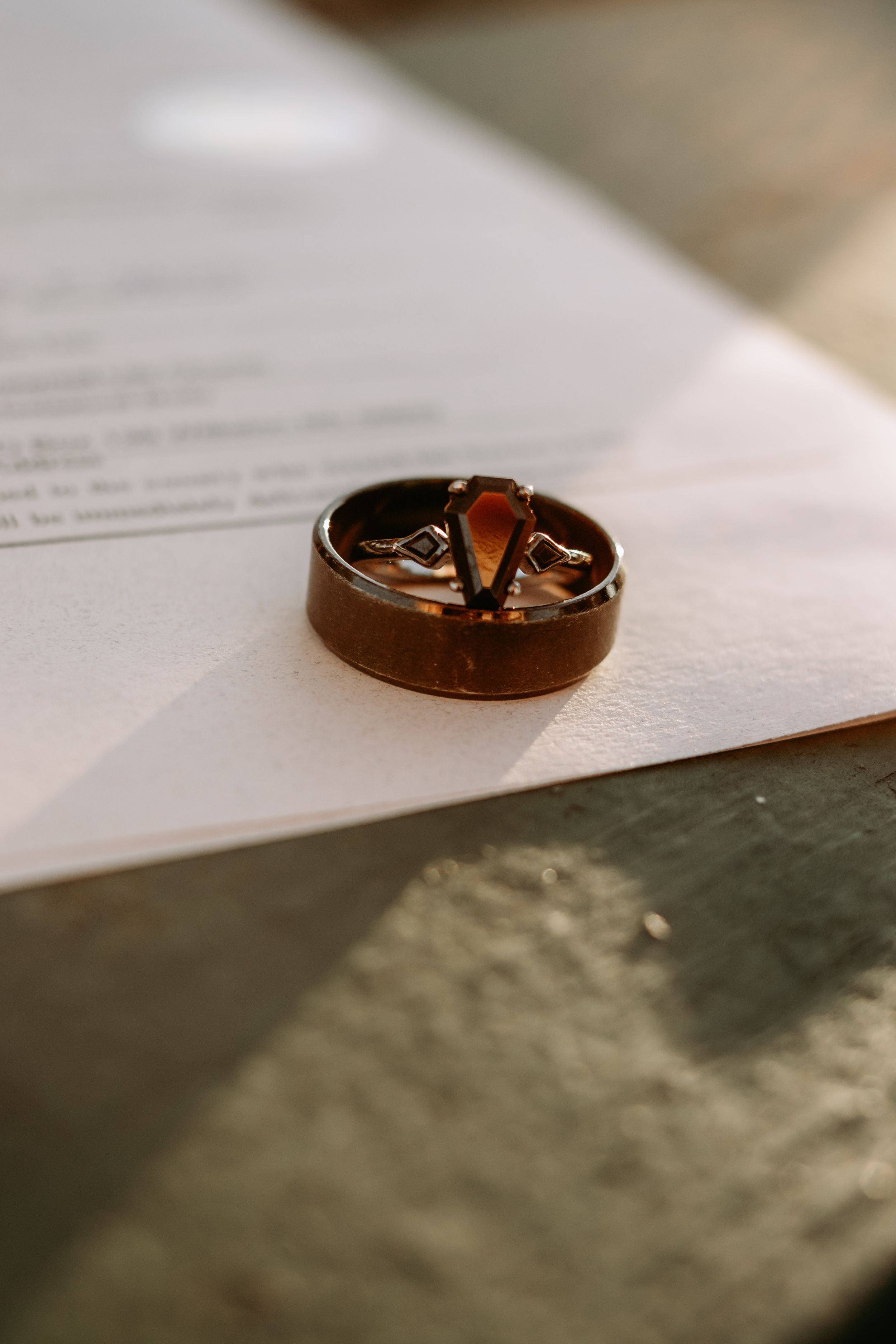 Close-up sequence of wedding rings on paper documents showing progressive focus and depth of field in Williston, North Dakota.