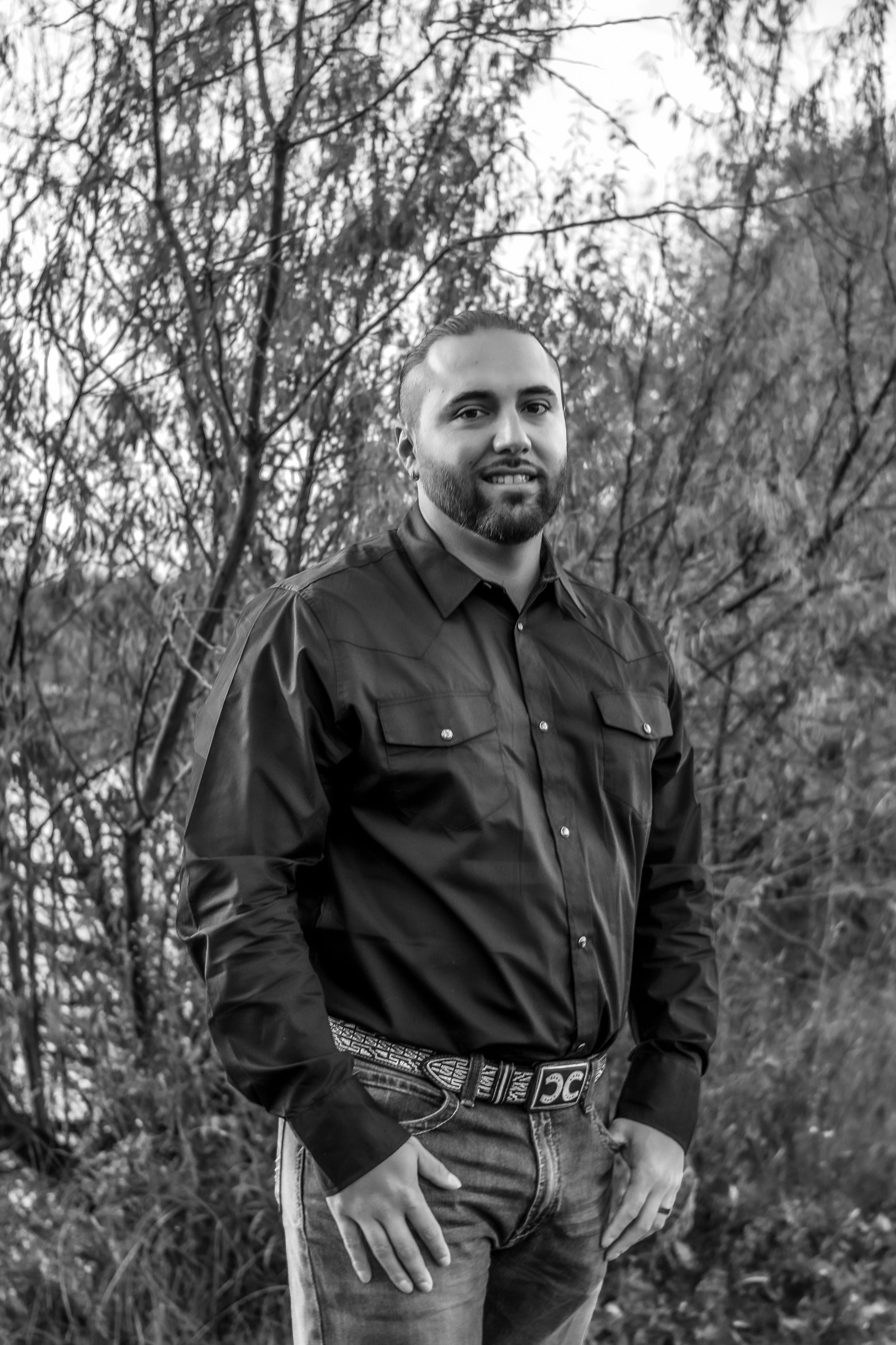 Black and white portrait series showing a person in dark clothing against a natural outdoor background with trees in Williston, North Dakota