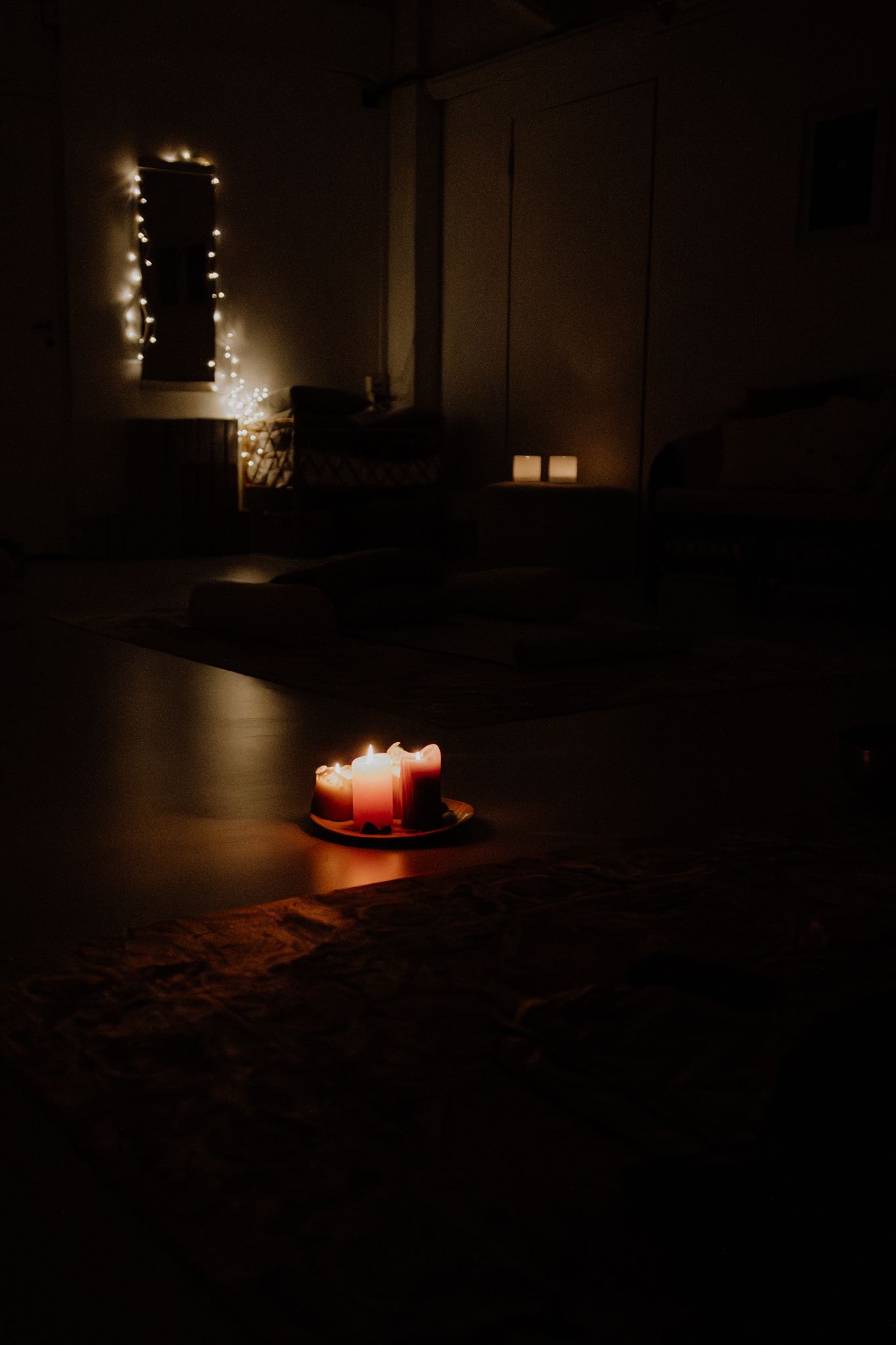 Sequence of dark moody images showing glowing candles creating atmospheric shadows and warm light in a dimly lit room.