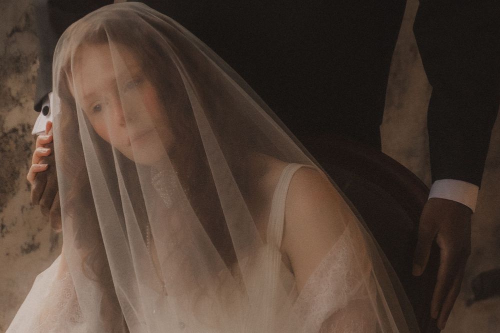 A bride wearing a delicate veil poses in a series of romantic and ethereal bridal portraits.