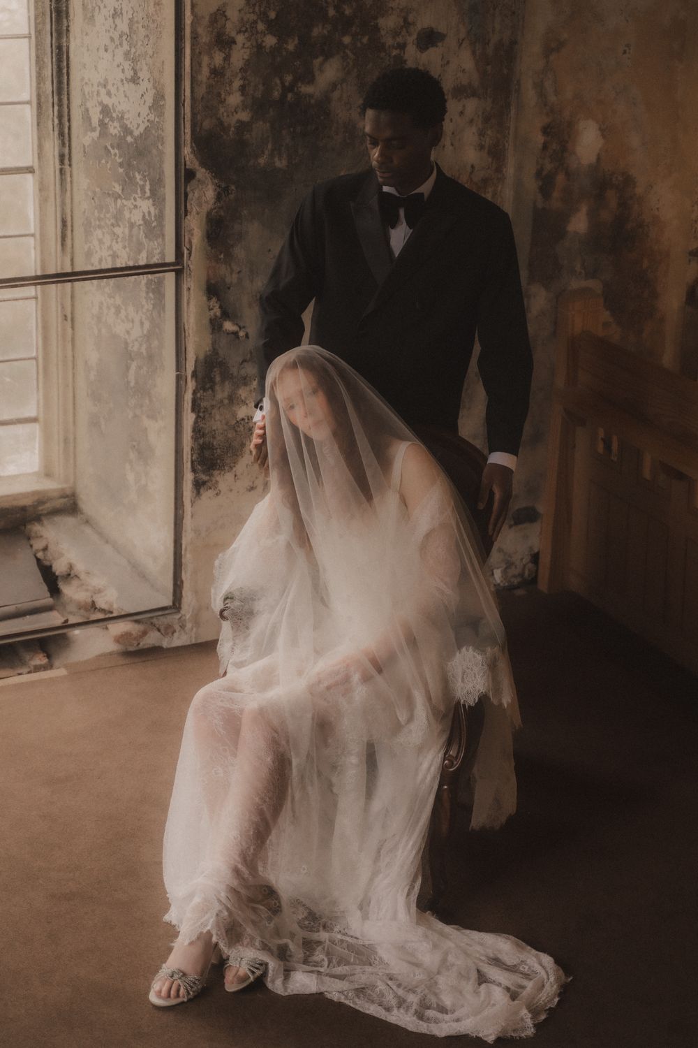 Artistic wedding photos showing bride in white dress and veil moving through an old rustic building interior.