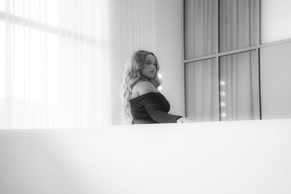 A black and white photo montage shows four connected images with curtains and window light creating a dreamy atmosphere.