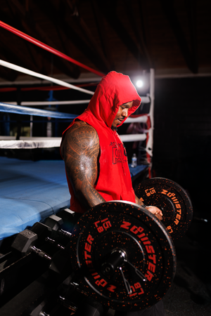A boxer in a red hoodie trains in a dimly lit boxing ring, shown in a sequence of dramatic action shots.