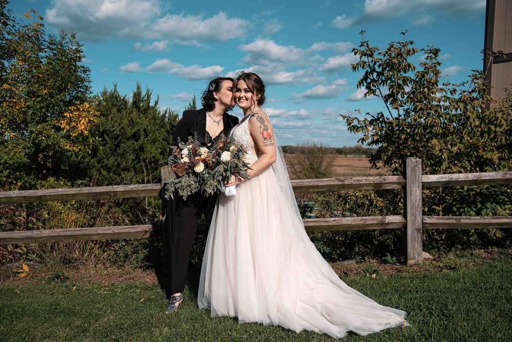 Two brides embracing at their outdoor Wisconsin wedding.