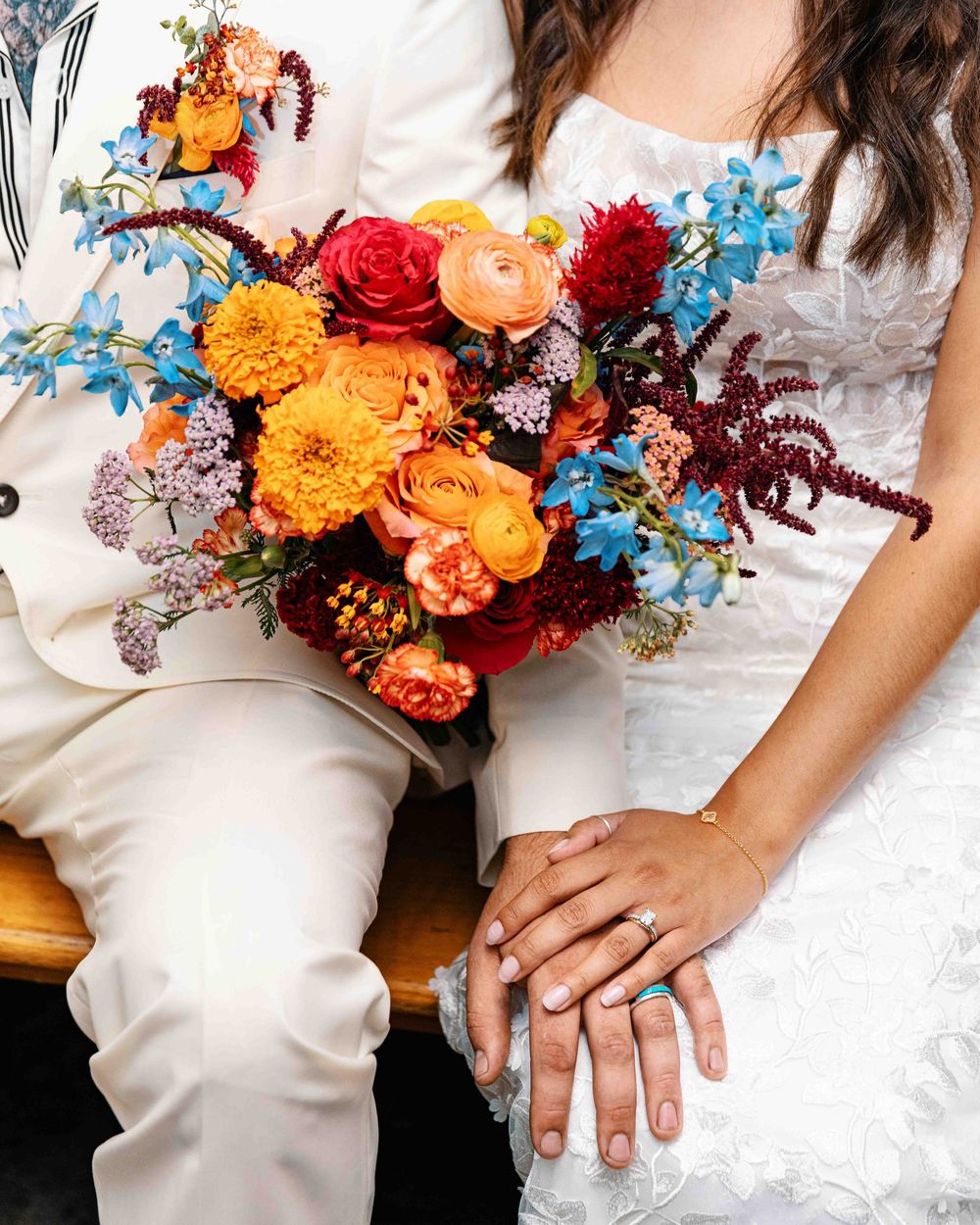 Detail portrait of bride and groom with floral bouquet.