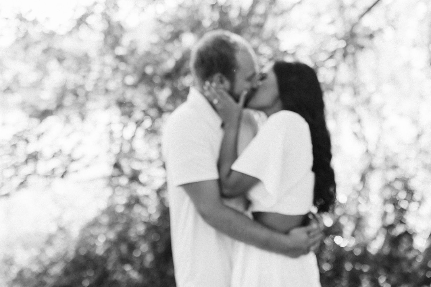 A romantic black and white photo series showing tender moments between a couple in an outdoor setting.