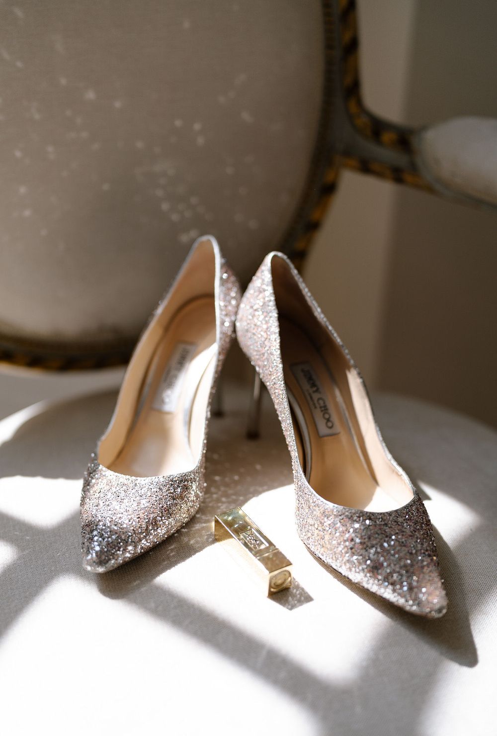 Sparkly silver glitter high heel shoes arranged in different angles on a white surface in natural light.