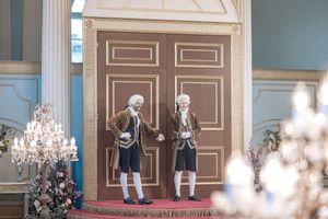 Behind the scenes of a Bridgerton Netflix filming setup at Newark Town Hall, showing two royal servants at the entrance door.