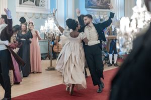Behind the scenes of a Bridgerton Netflix filming setup at Newark Town Hall, a focused shot on two cast dancers in the ballroom.